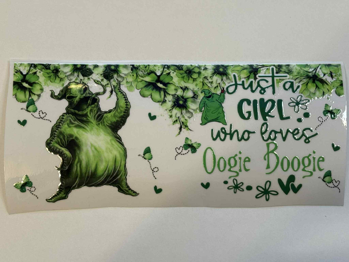 Green character with floral elements and text on a white background