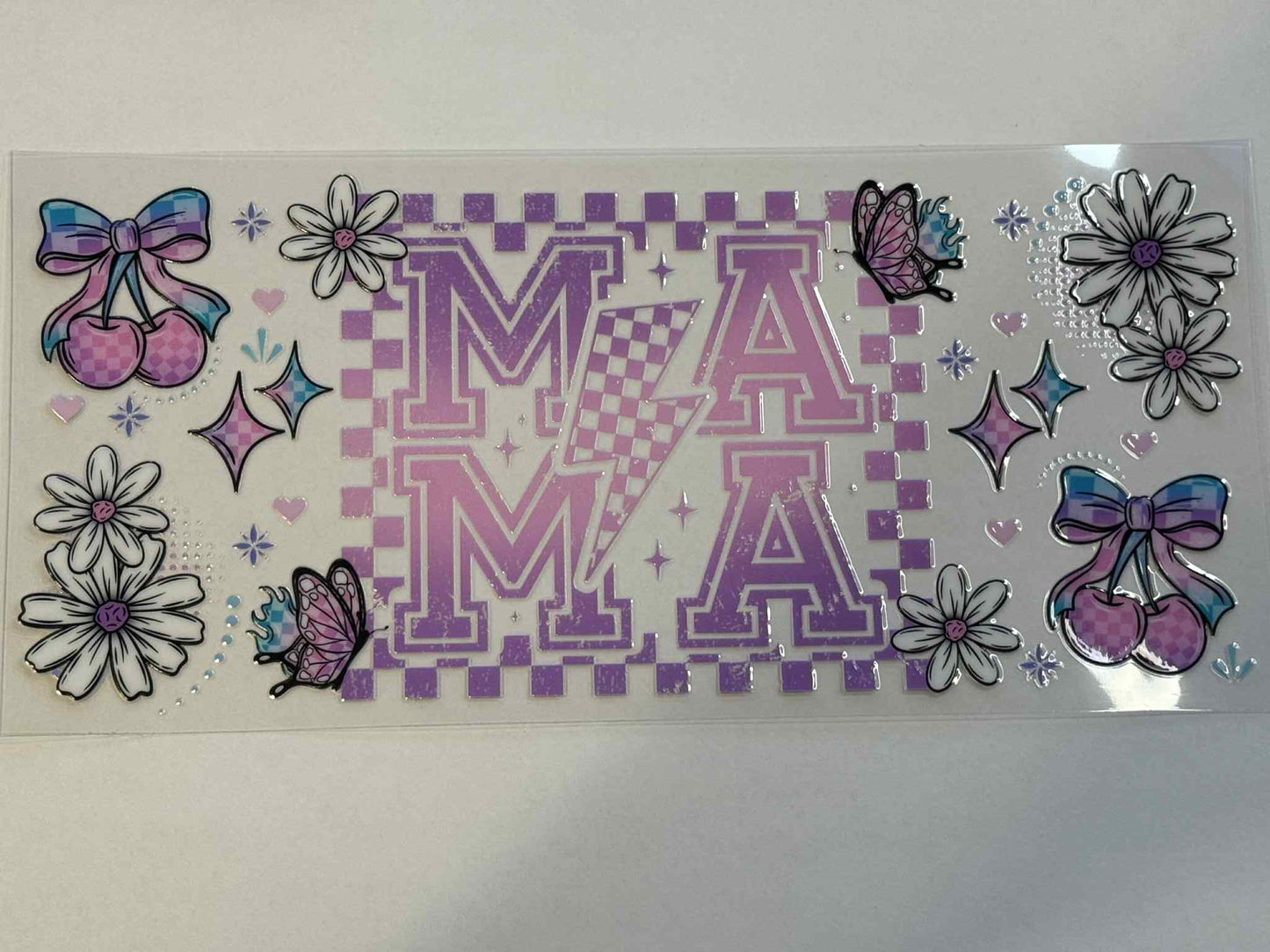 Decorative sticker sheet with letters 'MA', flowers, and bows on a checkered background.
