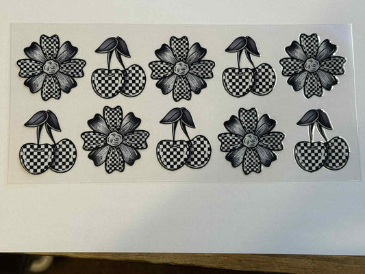 Sheet of black and white floral and checkered temporary tattoos on a white background.